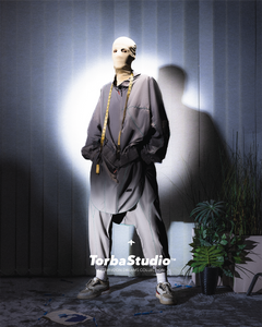 Mannequin wearing a gray outfit with a blurred background, featuring the Torba Studio logo.